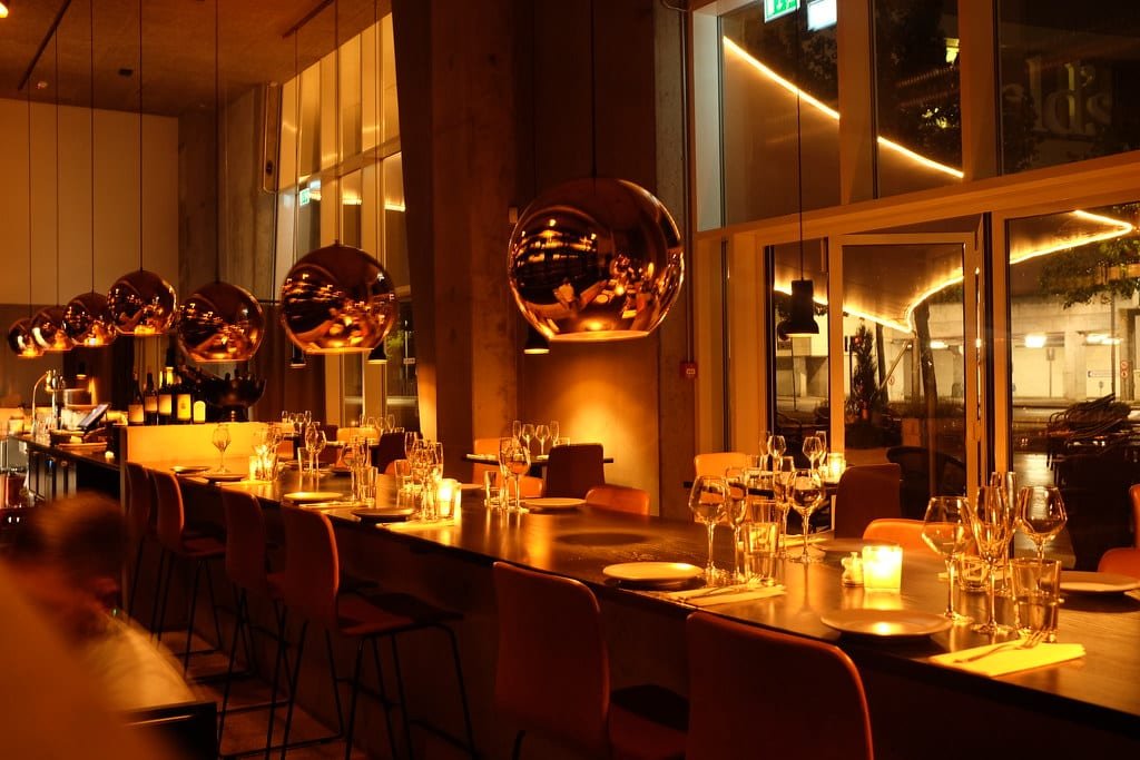 Restaurant tables under warm pendant lights